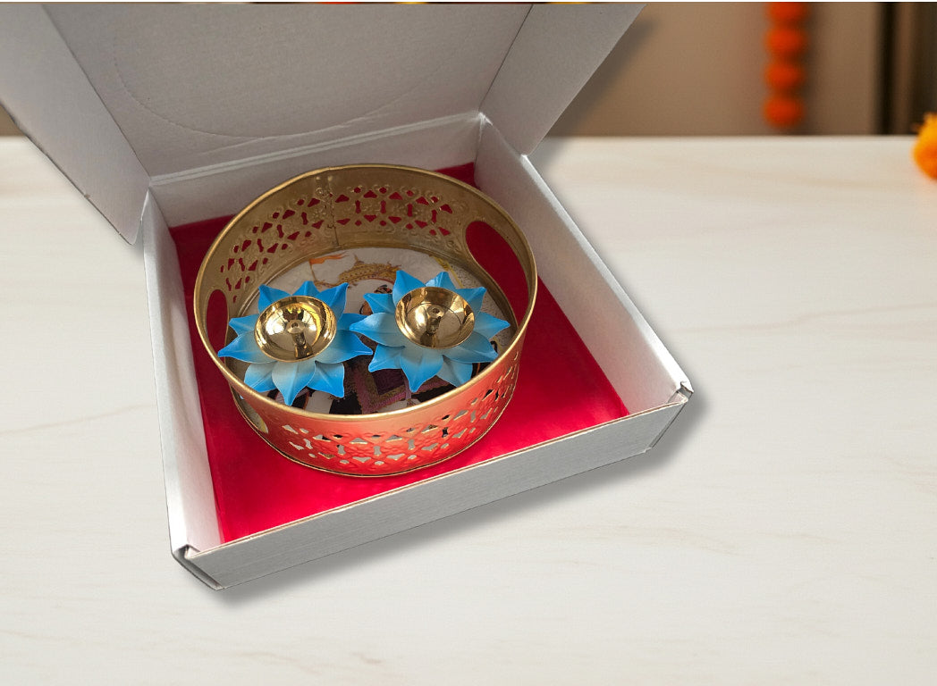 Diwali favor gift showing decorative gold basket with two bright blue lotus diyas in elephant print gift box with red lining