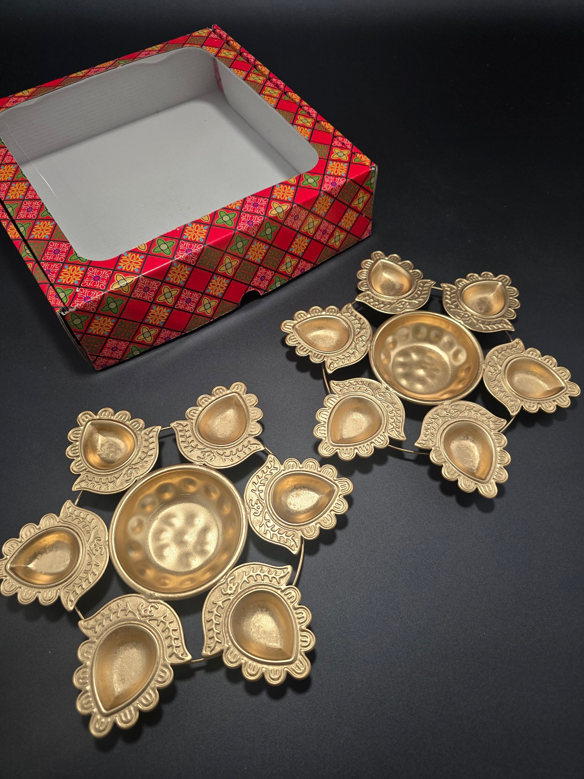 Set of two gold finish rangoli urli plates showing intricate mandala pattern with central diya and eight petal shapes for traditional Diwali lighting