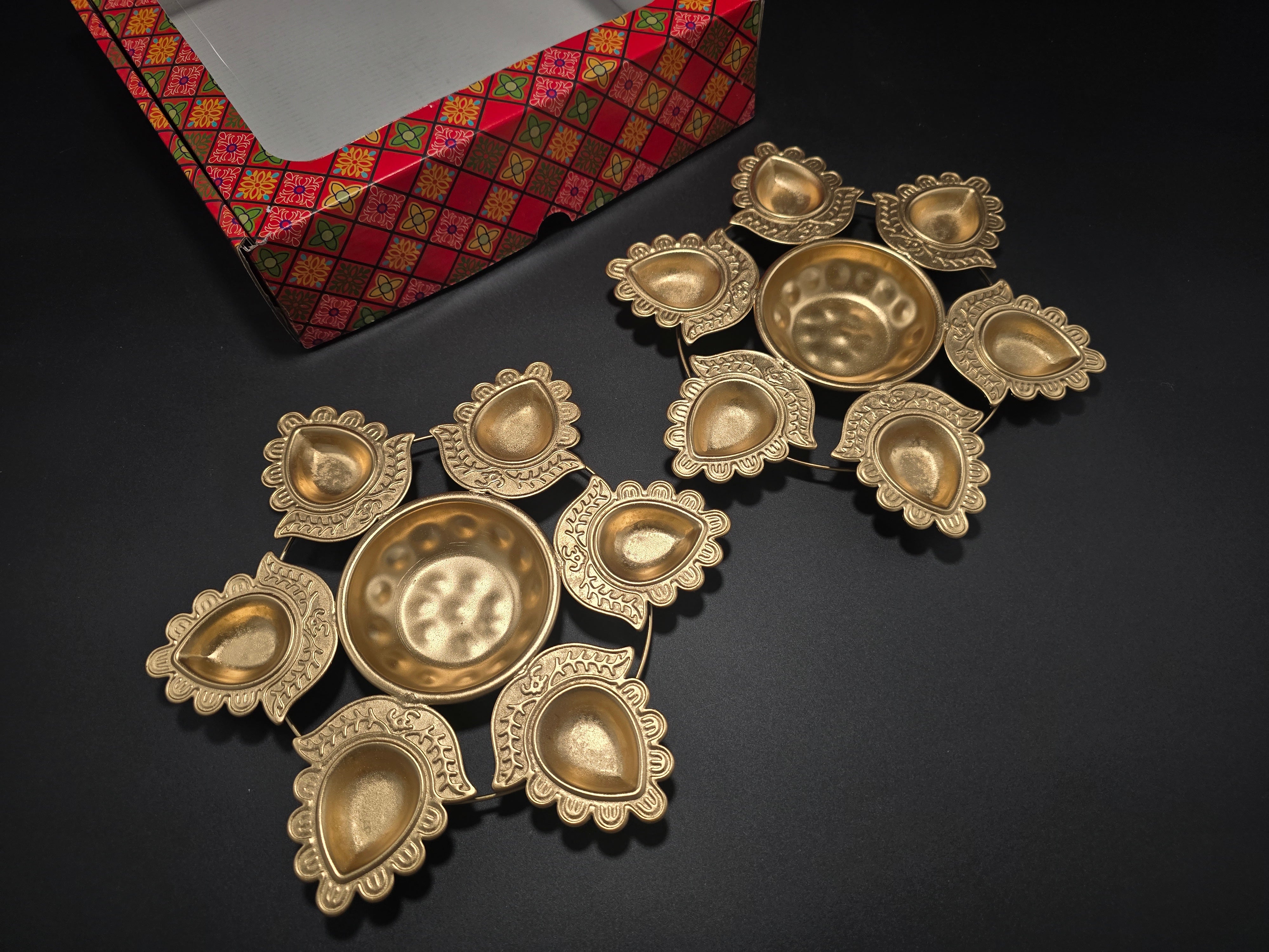 Detail view of traditional rangoli diya plates with decorative cutout pattern designed to hold oil and cotton wicks for authentic Diwali celebration