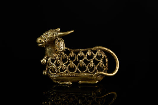 A clear side profile of the handcrafted Dhokra art Nandi Bull statue, showcasing its intricate filigree body against a black background