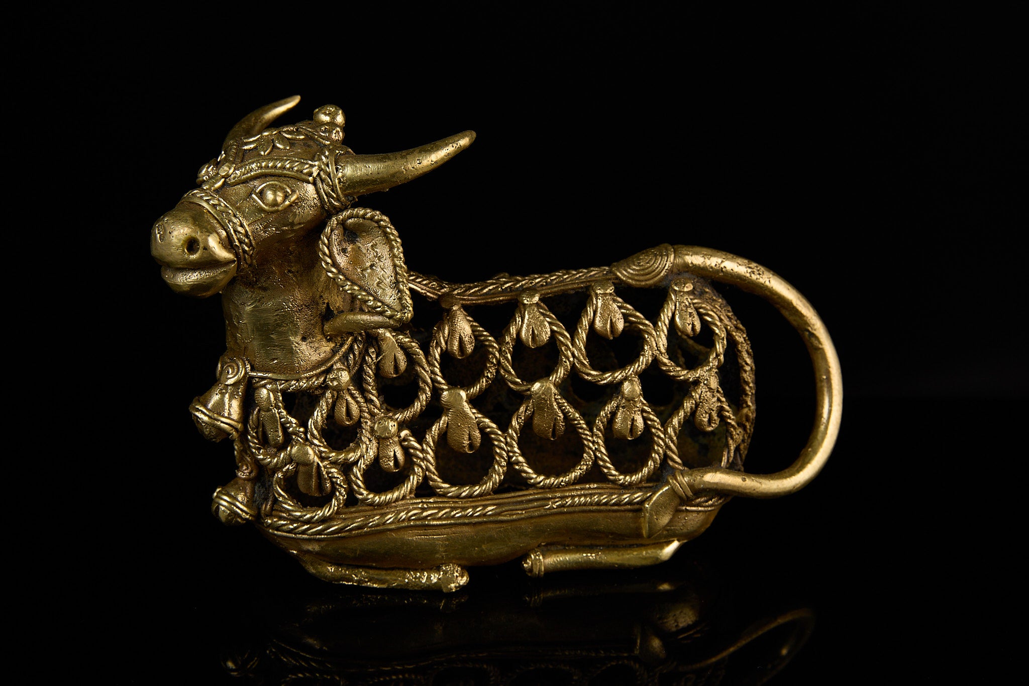A view focusing on the back half of the handmade Nandi Bull, detailing the texture of the Dhokra metalwork and the curve of the tail. 