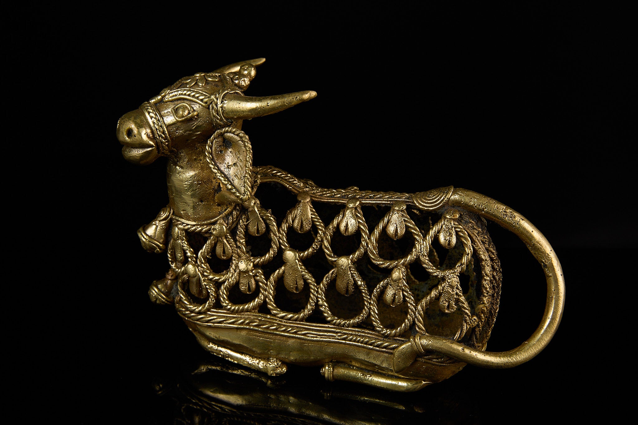 Close-up profile shot of the brass Nandi Bull's head and horns, emphasizing the artisan details and expressive face