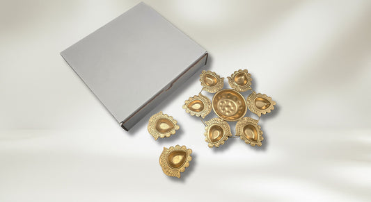 Urli and diya set showing single gold urli with two metal diyas in white corrugated box for budget-friendly Diwali centerpiece