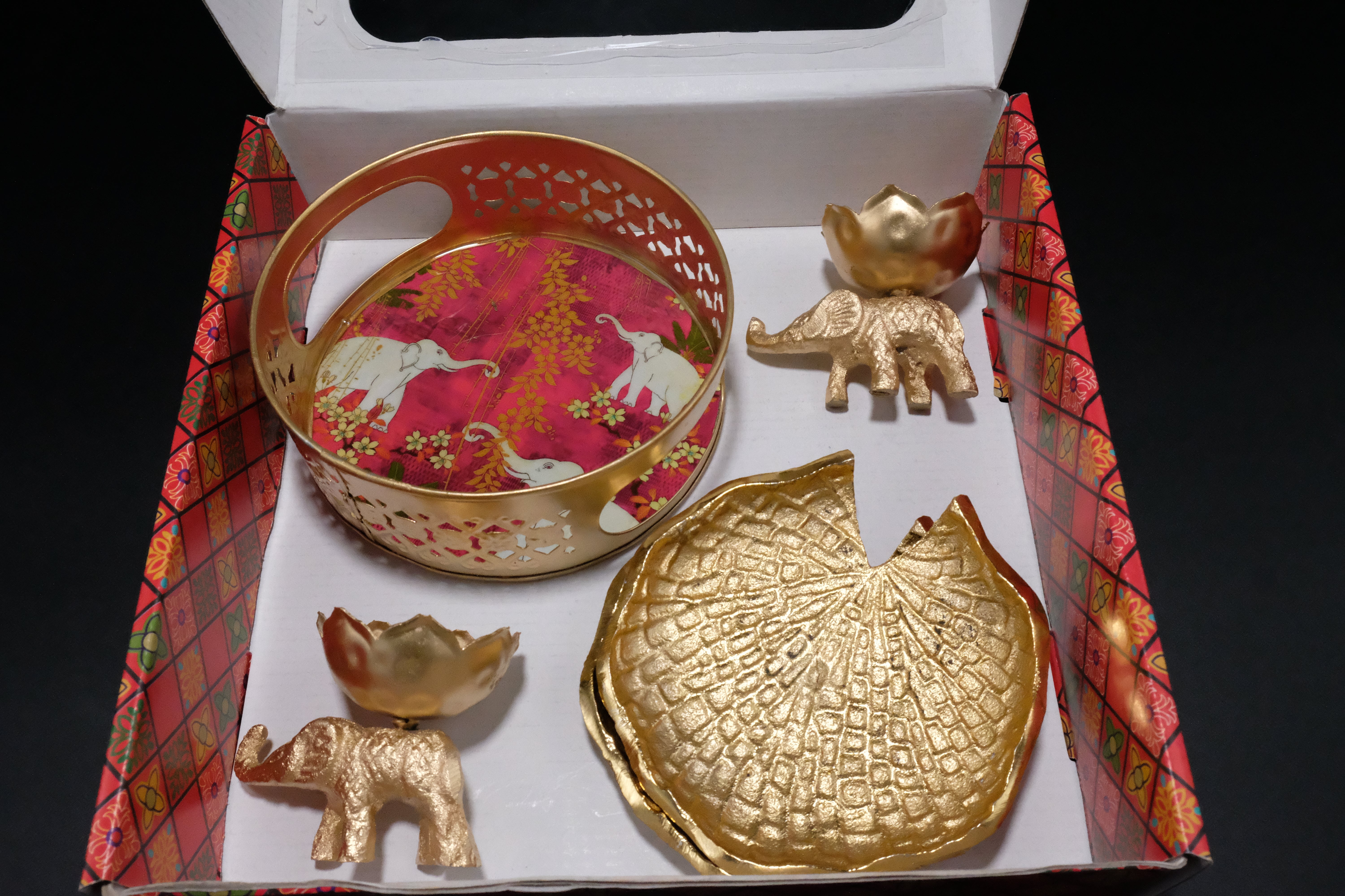 Angled view of premium Diwali gift box showing five-piece elephant themed set with gold finish basket diyas and decorative coasters