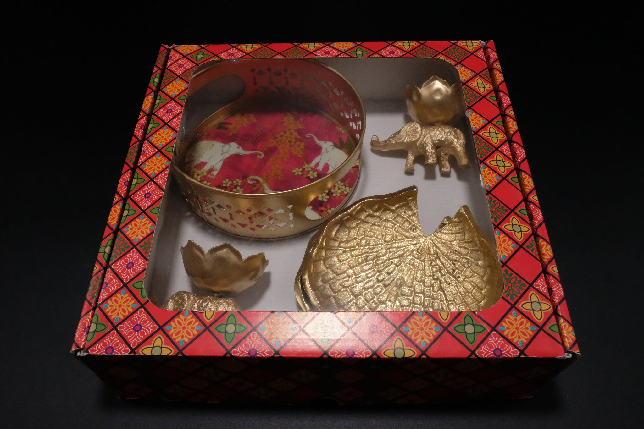 Overhead view of complete Diwali gift set in decorative box showing coordinated elephant theme across diyas basket and coasters