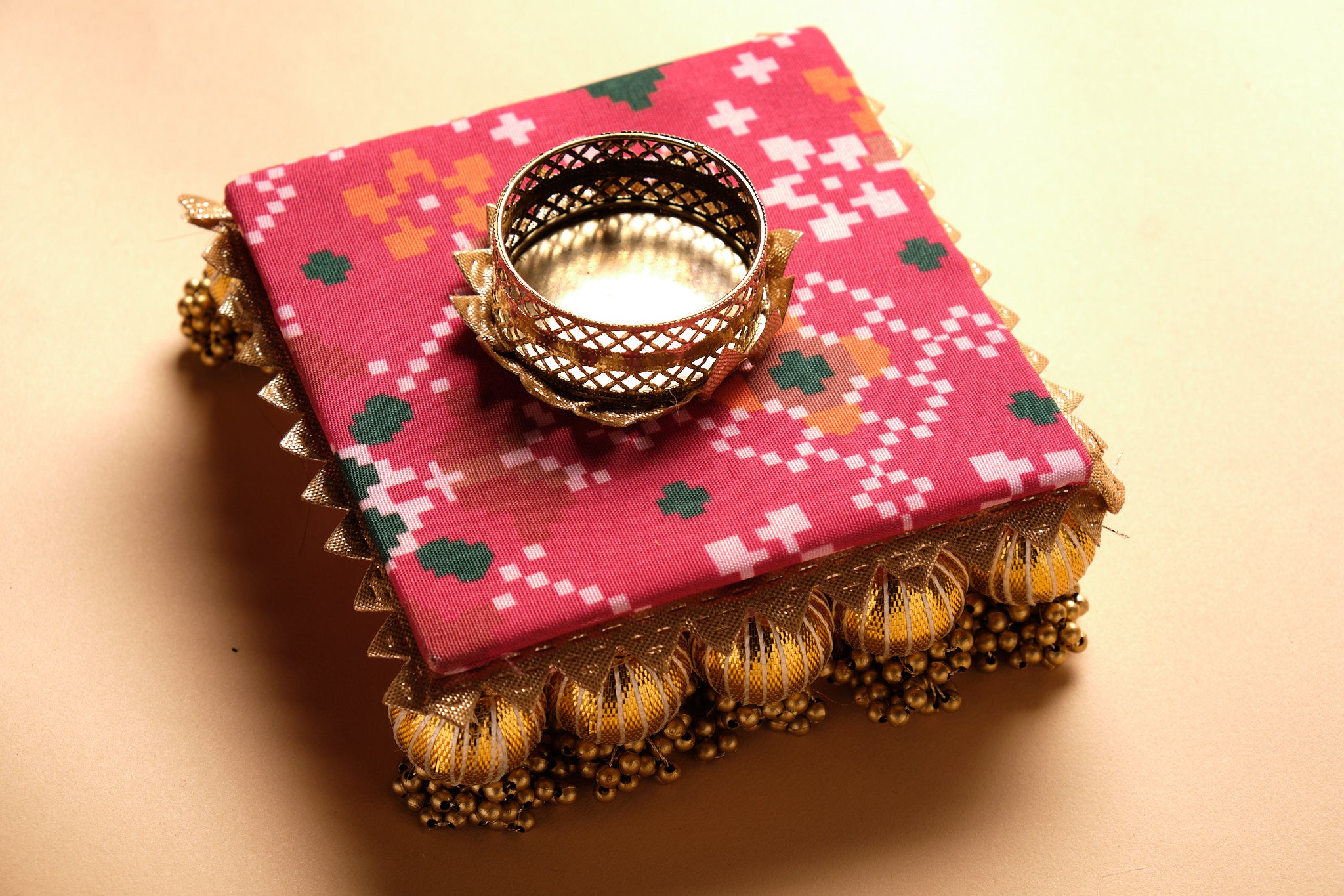 Detail view of fabric diya with gota work showing traditional Indian embellishment and tea light holder opening