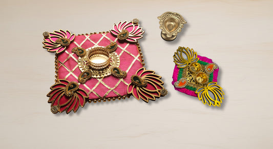 Diwali decor gift set showing vibrant pink rangoli mat with lotus designs metal peacock diya and haldi kumkum container three piece traditional setup