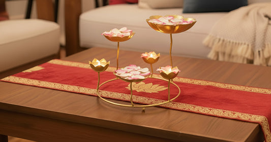 Premium standing urli centerpiece displayed on coffee table with floating rose petals in lotus bowls showing sculptural home decor in contemporary setting